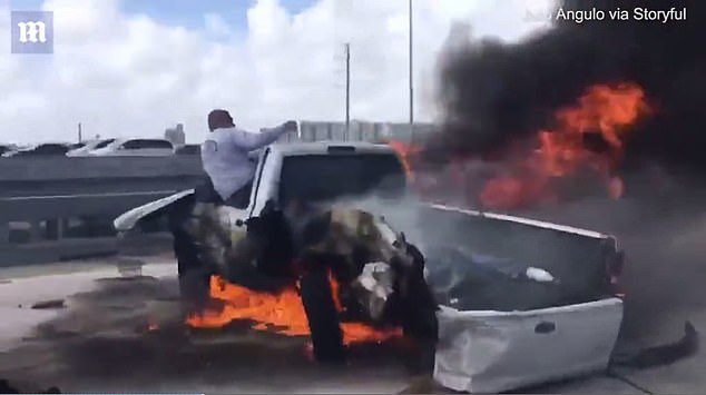 man pulls driver from burning car